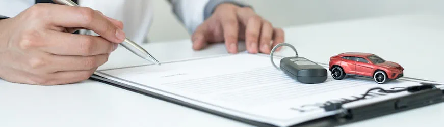 Une personne signant un contrat de location de voiture