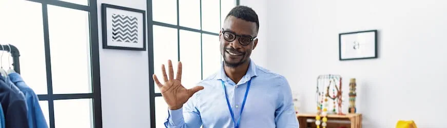 Un jeune apprenti vendeur qui travaille dans un magasin de vêtements