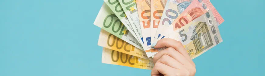 Une main qui tient plusieurs billets d’euros