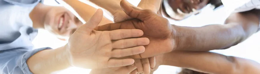un groupe de jeunes effectuant leur service civique et joignant leurs mains