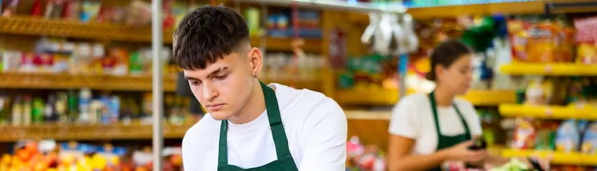 Un étudiant boursier qui travaille en dehors de ses commerces dans un commerce de détail.