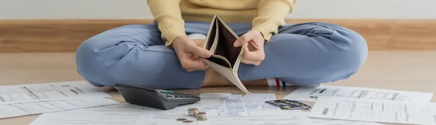 Une intérimaire avec des factures et un porte-monnaie vide, qui doit faire face à des difficultés financières.