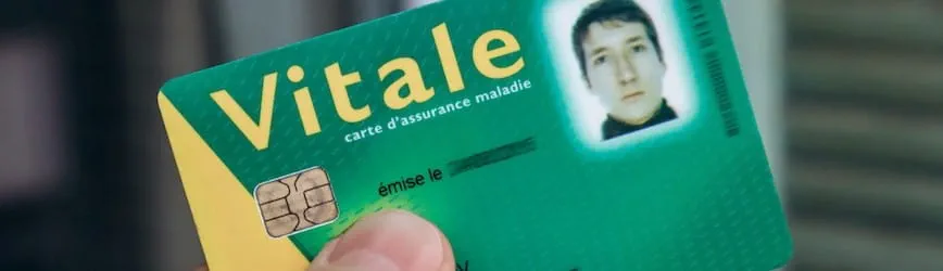 Une personne tient dans la main sa Carte vitale de Sécurité sociale.