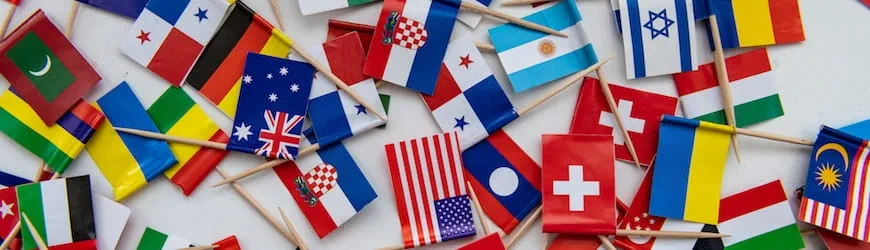 Un tas de petits drapeaux de pays mélangés, symbole de la variété des langues étrangères qui peuvent être utiles au travail.