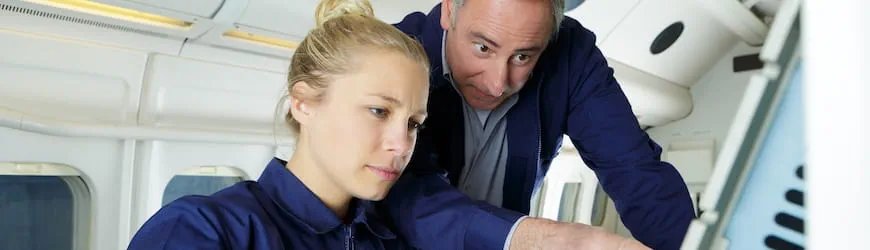 Une salariée et son chef d’équipe en train de travailler au câblage électrique d’un avion. 