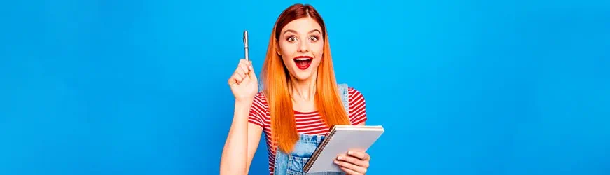 Jeune fille souriante sur fond bleu. Elle lève son stylo en l’air comme si elle avait une idée. Dans l’autre main, elle tient un bloc-notes Jeune fille souriante sur fond bleu. Elle lève son stylo en l’air comme si elle avait une idée. Dans l’autre main, elle tient un bloc-notes