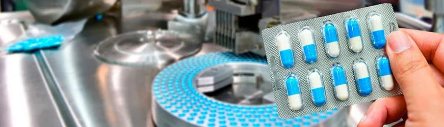 Un scientifique, dans un laboratoire, tient une plaquette de médicament dans sa main