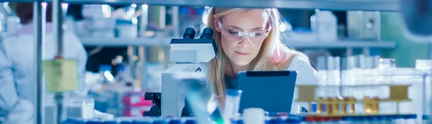 Une femme, dans un laboratoire, est concentrée sur son travail