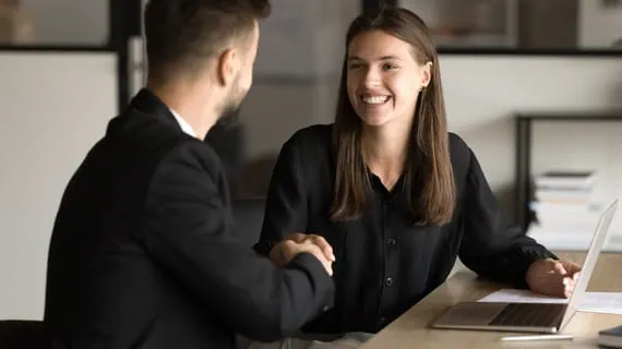 Lors d’un entretien d’embauche, une femme et un homme se serrent la main car ils ont conclu positivement l’entretien Lors d’un entretien d’embauche, une femme et un homme se serrent la main car ils ont conclu positivement l’entretien