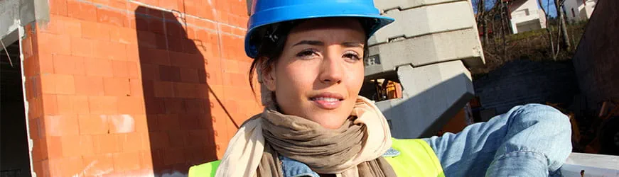 Une jeune femme portant un casque de chantier, ayant décidé de travailler et faire carrière dans le bâtiment.