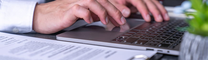 Main homme tapant au clavier avec document CV