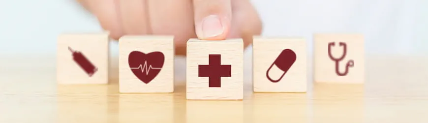 Une main qui dépose des cubes représentant différents soins remboursés par la mutuelle d’entreprise