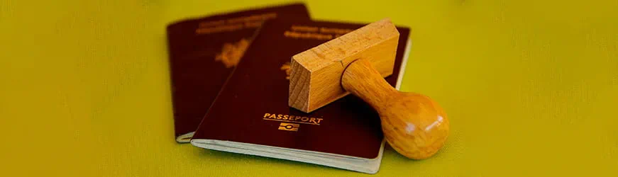 2 passeports posés sur une table avec un tampon encreur