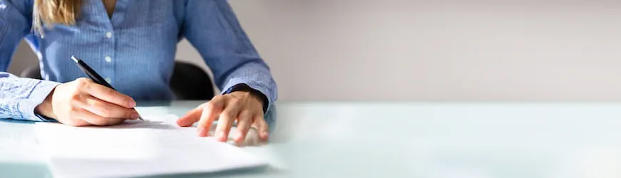 une jeune femme qui signe un contrat de travail