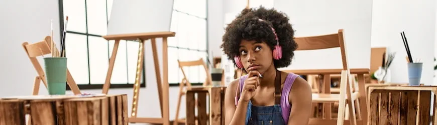 Une jeune femme qui réfléchit en rédigeant son CV sur un ordinateur portable