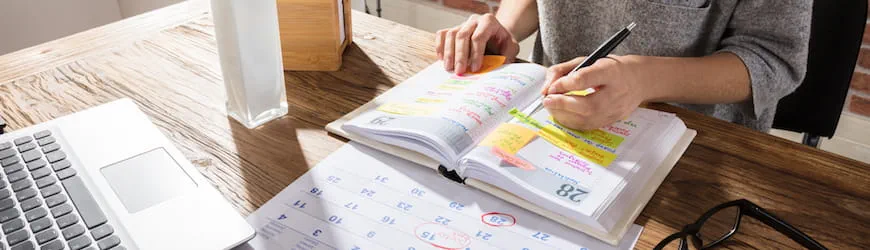 Une jeune femme qui consulte son agenda