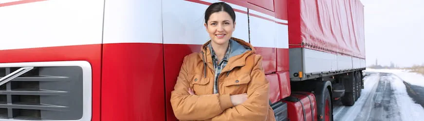 une jeune conductrice de poids lourds devant son camion