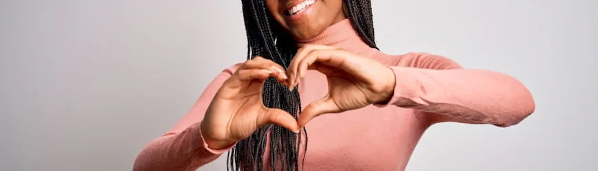 Une’ jeune femme heureuse d’avoir trouvé l’amour au travail, qui fait un coeur avec les mains. 