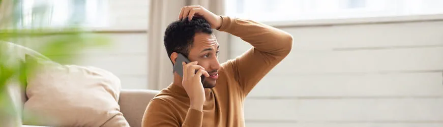 Un jeune homme qui parle avec une cellule d’écoute psychologique par téléphone
