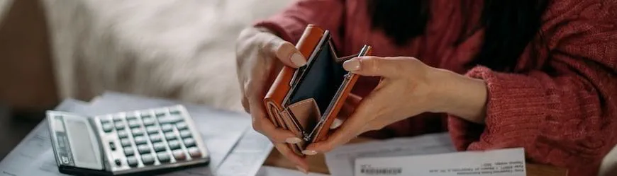 Une salariée en train de faire ses comptes et d’ouvrir un porte-monnaie vide : c’est peut-être le moment de demander un acompte sur salaire