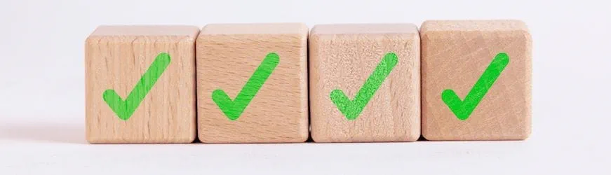 4 cases en bois sur lesquelles est affichée une coche verte, qui symbolise les compétences validées pendant un bilan de compétences