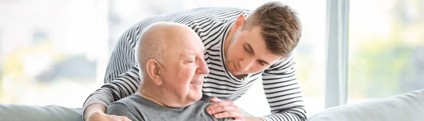 Un jeune homme qui aide son grand-père dépendant, en complément de son travail.