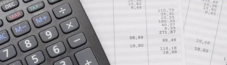 Une calculatrice et une fiche de paie de fin de mission d’intérim, qui comprend une prime de précarité.