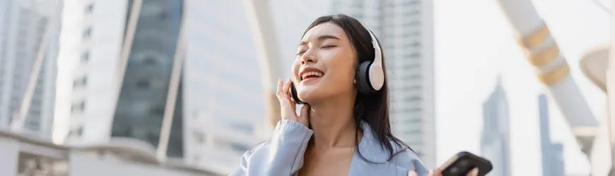 Une jeune femme écoute de la musique avec son casque, sur le chemin du travail. 
