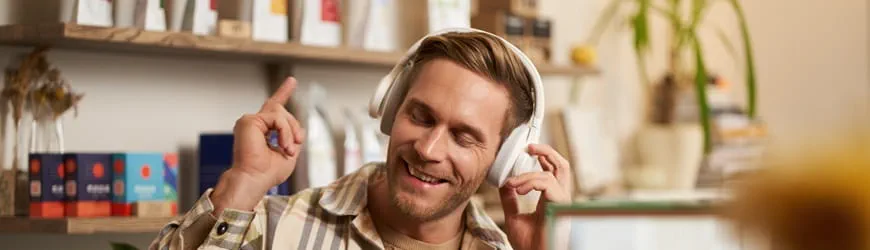 Un jeune homme écoute de la musique avec ses écouteurs à son travail.