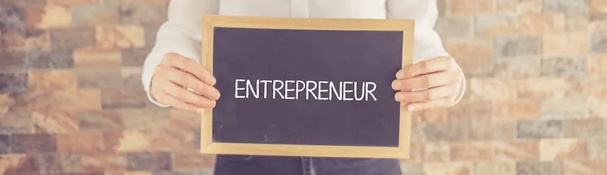 Un intérimaire qui tient un écriteau sur lequel est écrit “Entrepreneur”.