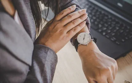 Une salariée qui consulte sa montre pour décompter les heures supplémentaires qu'elle vient de réaliser. Une salariée qui consulte sa montre pour décompter les heures supplémentaires qu'elle vient de réaliser.