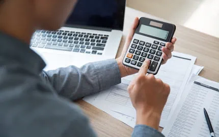 Un chargé de ressources humaines qui évalue le montant des aides à l'embauche d'une personne en situation de handicap, sur une calculette. Un chargé de ressources humaines qui évalue le montant des aides à l'embauche d'une personne en situation de handicap, sur une calculette.