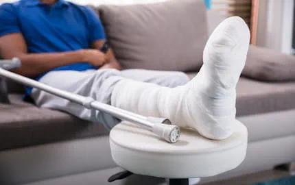 La jambe bandée et la béquille d'un salarié blessé dans le cadre d'un accident du travail. La jambe bandée et la béquille d'un salarié blessé dans le cadre d'un accident du travail.