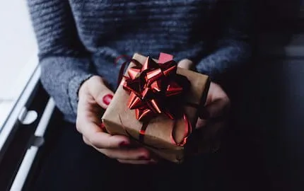 Une salariée tient dans ses mains un cadeau de fin d'annnée offert par son entreprise. Une salariée tient dans ses mains un cadeau de fin d'annnée offert par son entreprise.