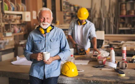 Un artisan dans son atelier, à côté d'un salarié recruté grâce à une aide à l'embauche 2024.