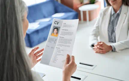 Une recruteuse consulte le CV d’une candidate avant d’en contrôler les références. 