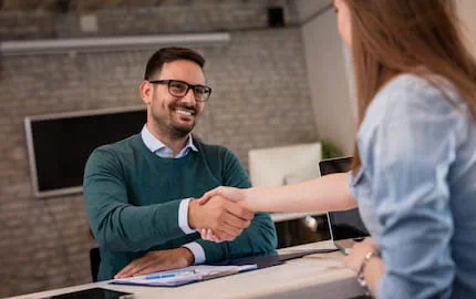 Un chef d'entreprise qui serre la main d'une salariée, recrutée en CDI à l'issue d'une mission d'intérim. Un chef d'entreprise qui serre la main d'une salariée, recrutée en CDI à l'issue d'une mission d'intérim.