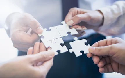 Plusieurs mains qui rapprochent des morceaux de puzzle, symbole du d'intégration d'une nouvelle recrue. Plusieurs mains qui rapprochent des morceaux de puzzle, symbole du d'intégration d'une nouvelle recrue.