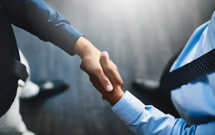 Deux chefs d’entreprise qui se serrent la main, en train de mutualiser leur ressources collaboratives.