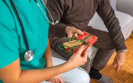 Un membre du personnel soignant recevant un cadeau pour noël. Un membre du personnel soignant recevant un cadeau pour noël.
