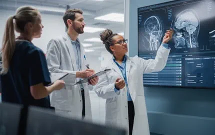 cadre de santé montre une radio d’un patient à ses collègues radiologues sur un tableau connecté dans un hôpital cadre de santé montre une radio d’un patient à ses collègues radiologues sur un tableau connecté dans un hôpital