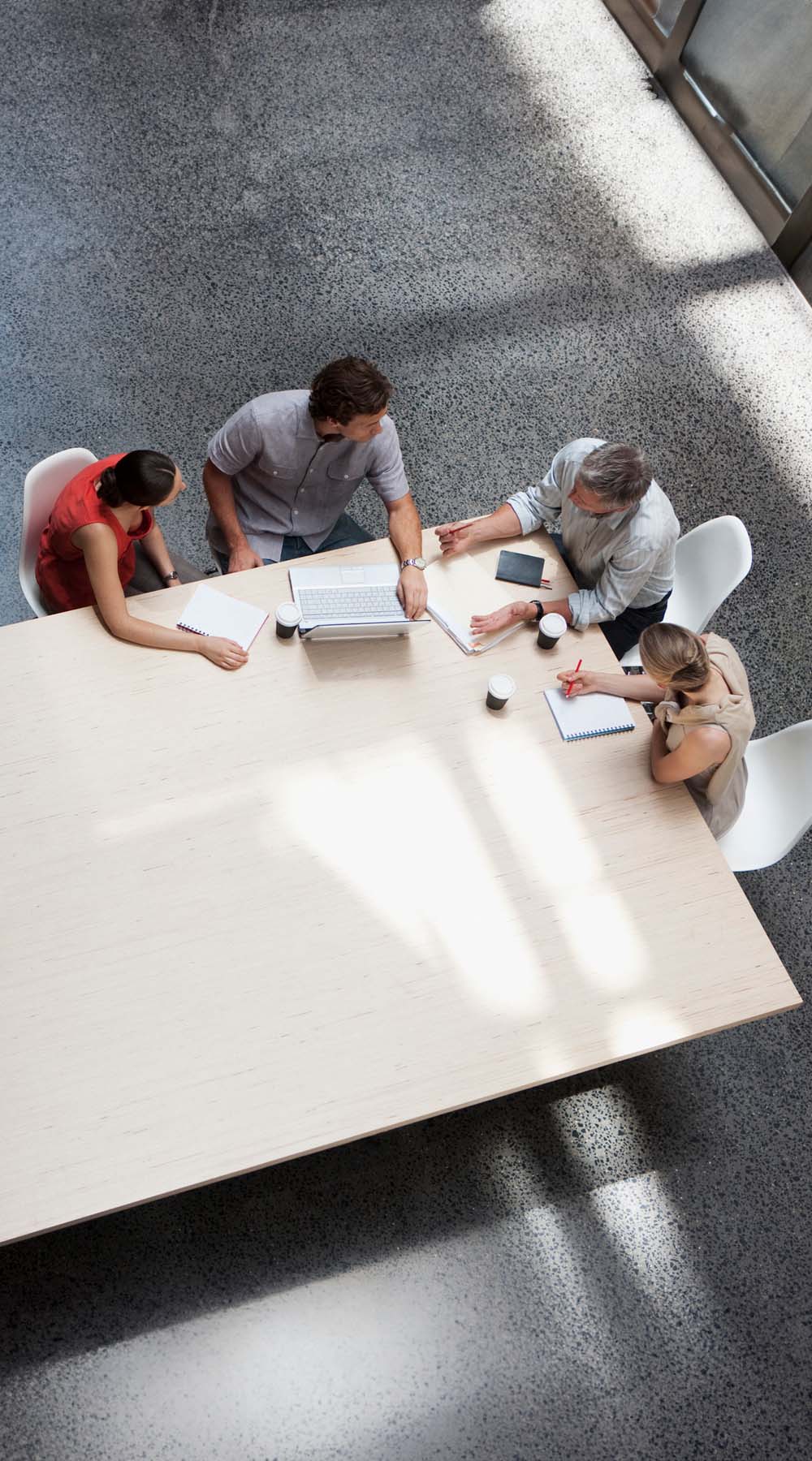 Grupo de cuatro personas reunidos alrededor de una mesa Grupo de cuatro personas reunidos alrededor de una mesa