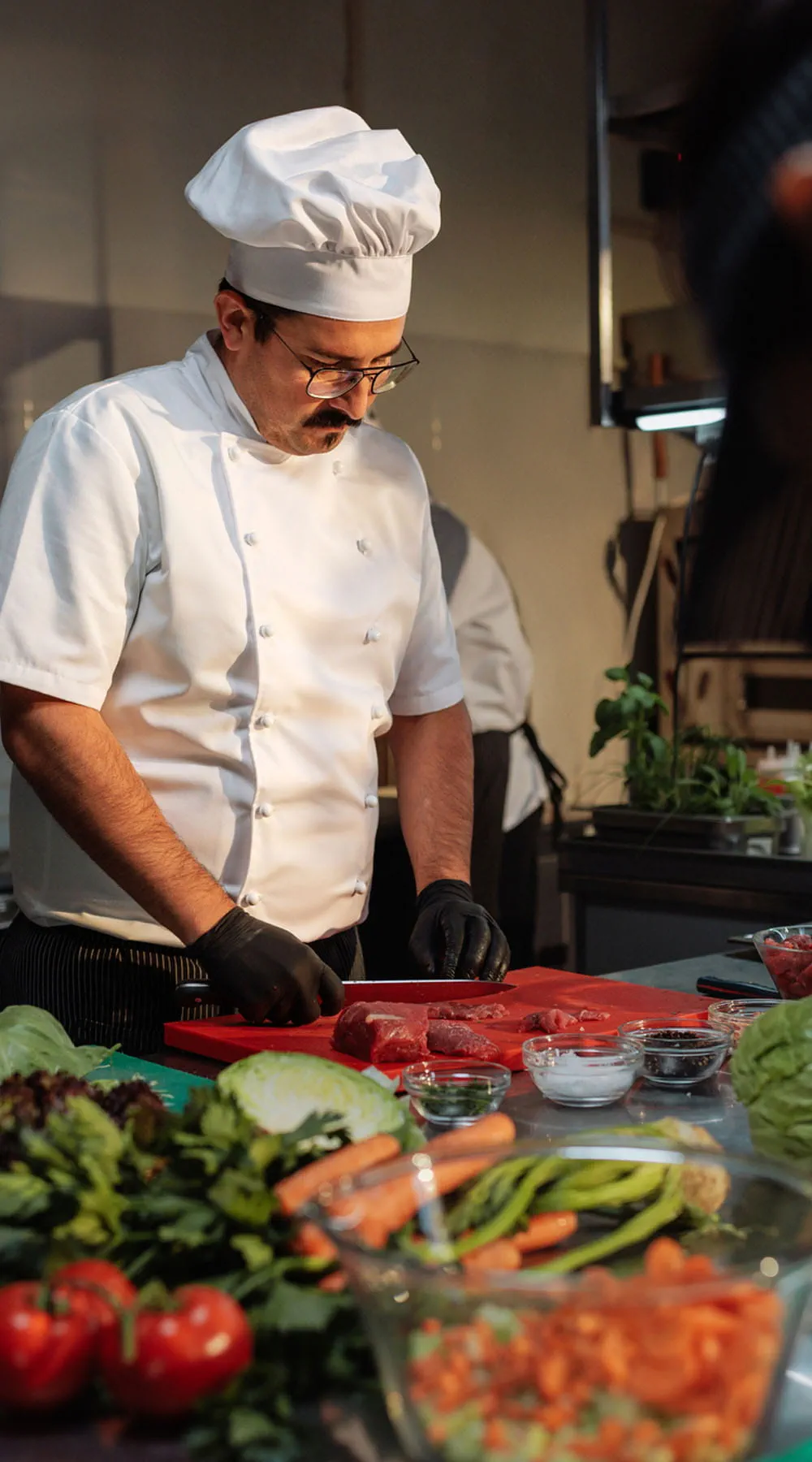 Chef cortando carne con precisión en la ajetreada cocina de un restaurante Chef cortando carne con precisión en la ajetreada cocina de un restaurante