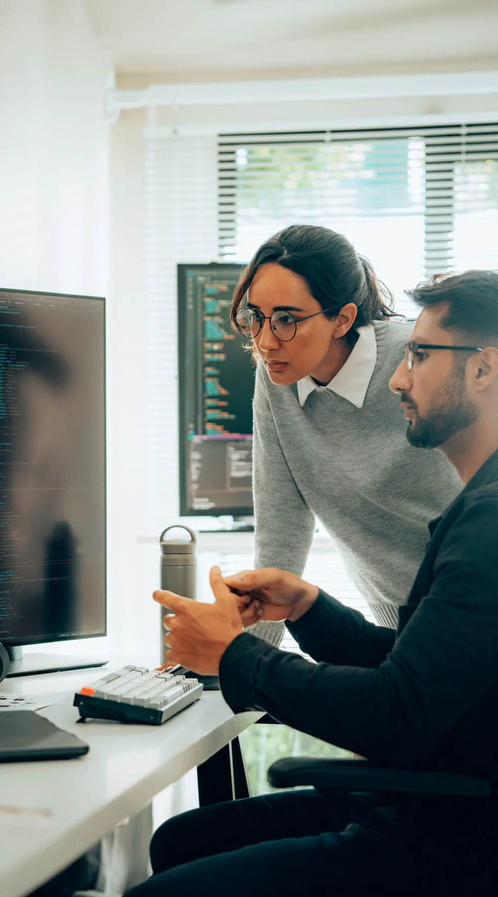 Dos profesionales trabajando en una sala de control