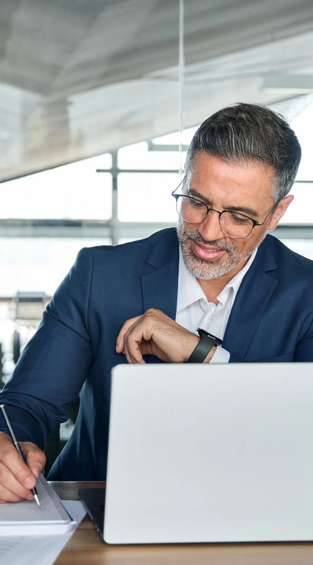 Hombre de negocios trabajando en una computadora portátil en la oficina escribiendo notas Hombre de negocios trabajando en una computadora portátil en la oficina escribiendo notas