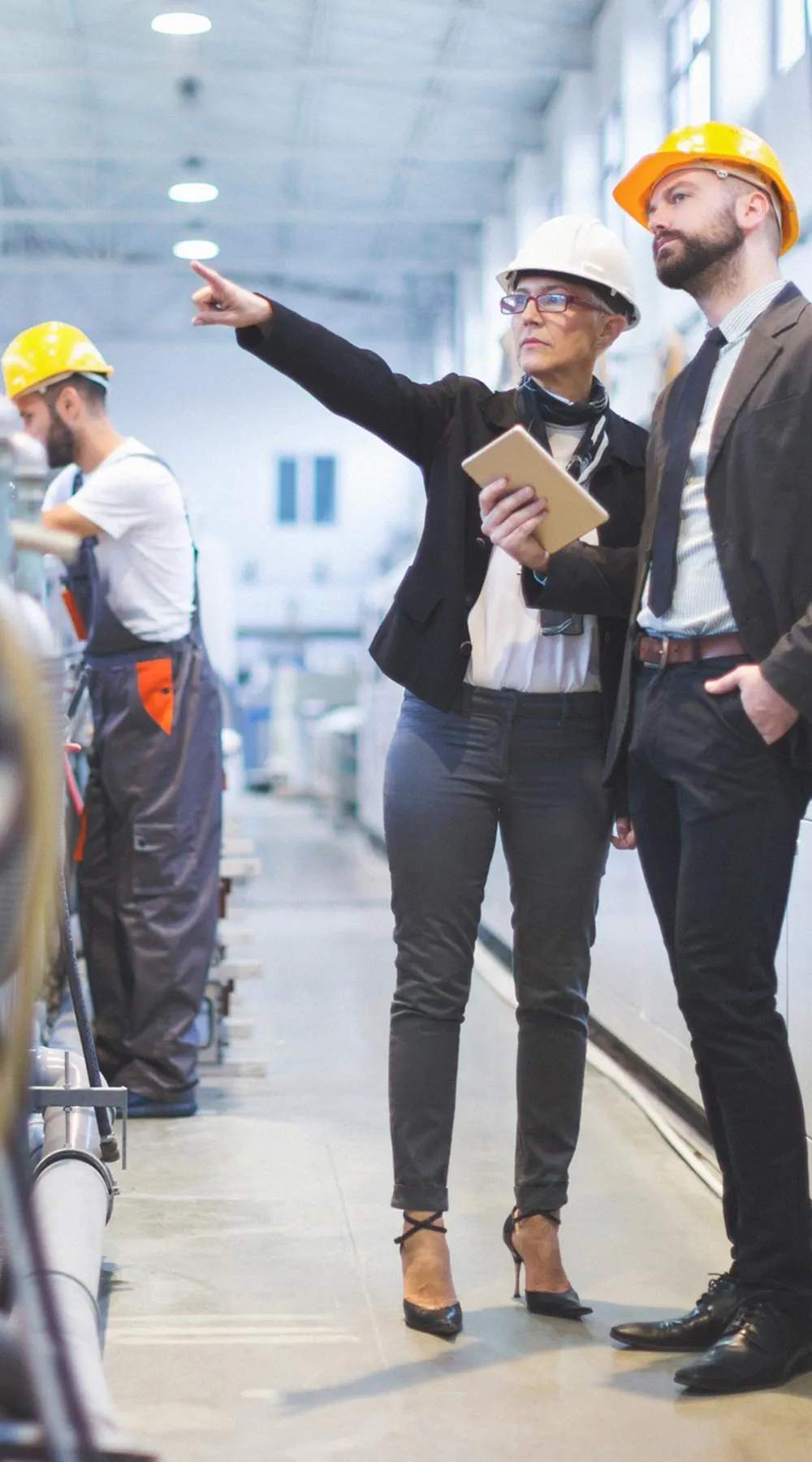 Dos personas con casco revisando línea de producción Dos personas con casco revisando línea de producción