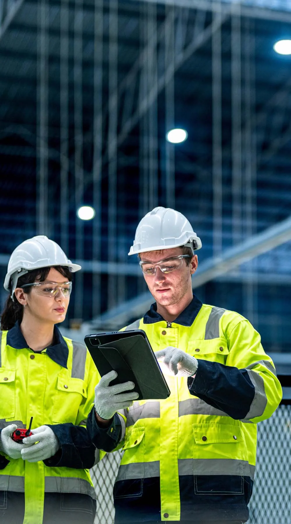 Dos ingenieros con ropa de trabajo controlan el sistema de producción Dos ingenieros con ropa de trabajo controlan el sistema de producción