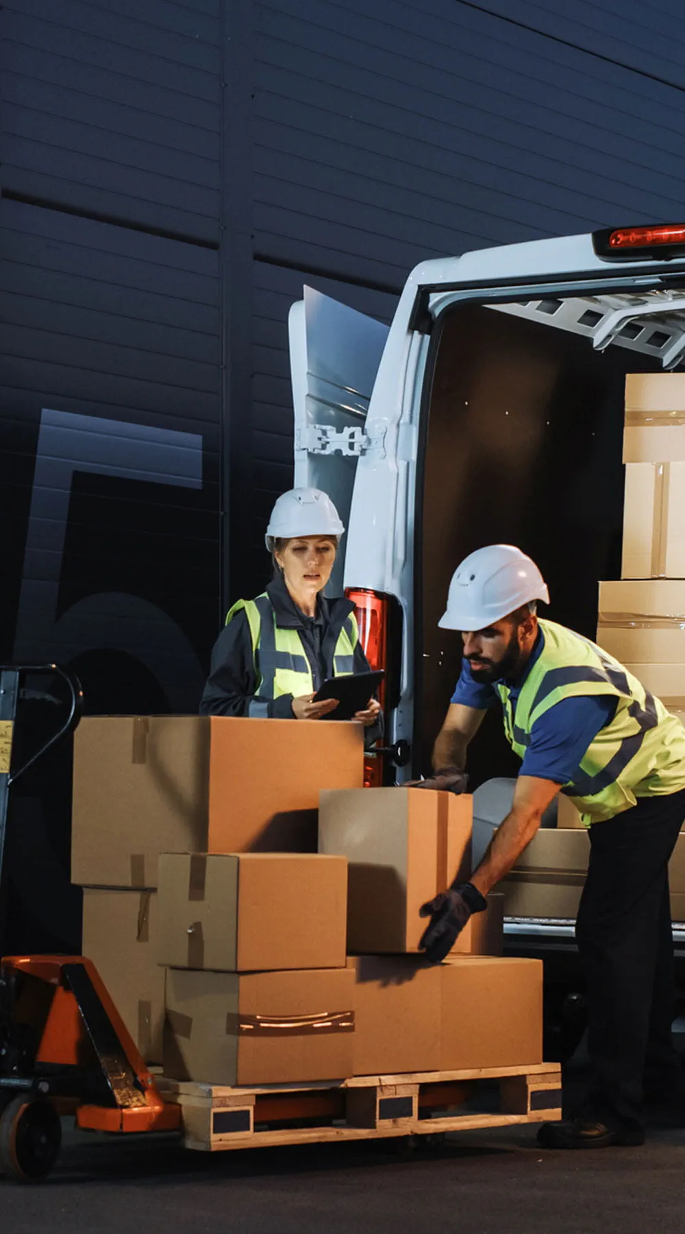 Dos personas bajando cajas de una furgoneta Dos personas bajando cajas de una furgoneta