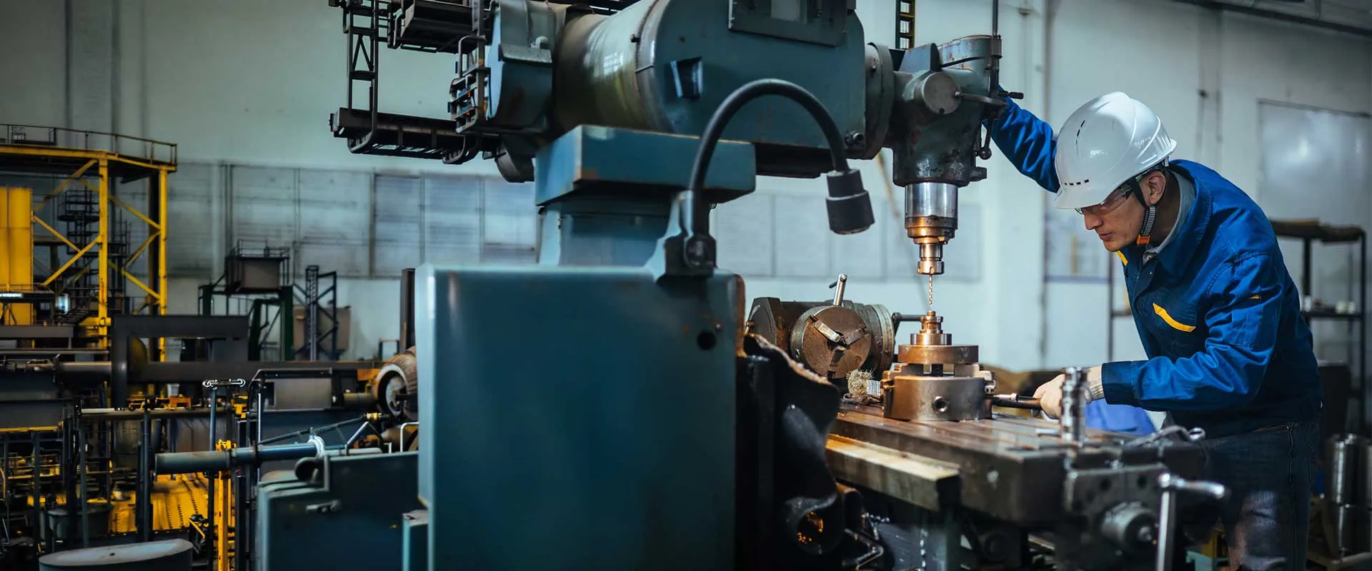 Ingeniero trabajando con un torno en una fábrica del metal Ingeniero trabajando con un torno en una fábrica del metal