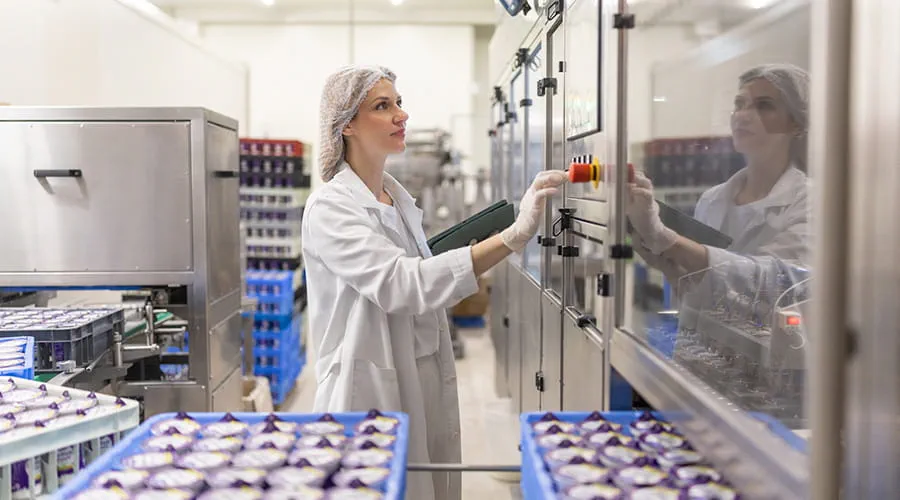 Mujer revisando máquinas en fábrica de alimentos Mujer revisando máquinas en fábrica de alimentos